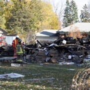 Des pompiers fouillent les décombres d'une maison détruite par une explosion et un incendie le 12 novembre 2023, dans l'est de Toronto.