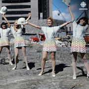Hôtesses en uniforme posant sur le chantier de construction de la Maison de
Radio-Canada.