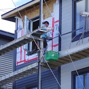 Un travailleur de la construction monté dans un échafaud.