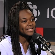 Une jeune femme portant un chandail mauve est en entrevue à l'émission Point du jour.