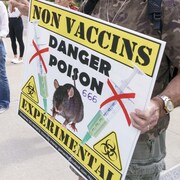 Gros plan sur une pancarte que brandit un manifestant lors d'un rassemblement antivaccin devant un hôpital montréalais. On peut lire Non Vaccins, Danger poison, 666, Expérimental.