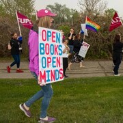 Les travailleurs du SCFP, du Brandon Pride, Pflag, du Knox United Church Affirm Committee et des manifestants lors d’une marche tenue à Brandon, le 17 mai 2023, en soutien à la communauté LGBTQ. Une affiche qui indique « Les livres ouverts d’esprit. »
