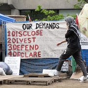 Une pancarte installée sur une clôture du campement, décrivant les demandes des manifestants. 