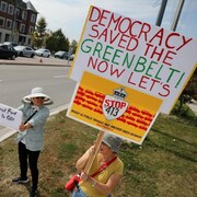Des manifestants tiennent des pancartes.