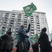 Un gréviste brandit un drapeau du Front commun.