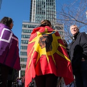 Des femmes, de dos, portant des drapeaux sur les épaules, lors d'une manifestation à Montréal en 2016.