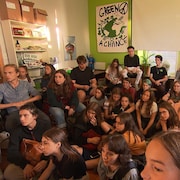 Des jeunes rassemblés dans une pièce.