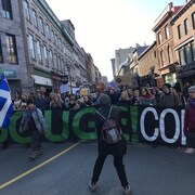 Des manifestants défilent sur la rue Saint-Jean, brandissant des pancartes demandent plus d'actions pour lutter contre le réchauffement de la planète.