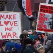 Manifestants rassemblés sur la Première Avenue de New York. Sur une affiche, le slogan: «Make love not war».