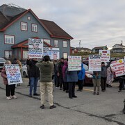 Des manifestants avec des pancartes devant les bureaux de la CTMA.