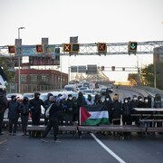 Des manifestants bloquent l'accès au pont Jacques-Cartier avec une table à pique-nique et des bancs de parc. 