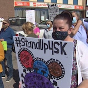 Des manifestants lors d'un rassemblement le 8 septembre devant le bureau de circonscription du ministre de la Santé Paul Merriman, à Saskatoon.
