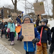 Des écoliers manifestent sur un trottoir près de l'école Anne-Hébert à Québec.