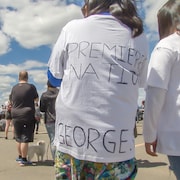 Des manifestants. Une femme porte un chandail où on peut y lire : Premières Nations / George. F.