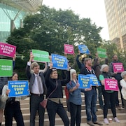 Des manifestants tiennent des pancartes colorées.