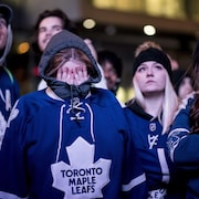 Les amateurs des Maple Leafs de Toronto montrent leur déception après avoir regardé la défaite de leur équipe devant le grand écran au Maple Leaf Square au centre-ville de Toronto.