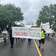 Des grévistes tiennent une banderole pour dénoncer l'inaction de Bruno Marchand.