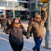 Un homme et une femme se tiennent par la main lors de la marche pour la journée la plus froide de Regina.