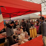 Des gens s'arrêtent à un kiosque de nourriture.