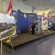 La dame devant un lutrin installé pour une conférence de presse à la base militaire de Bagotville.