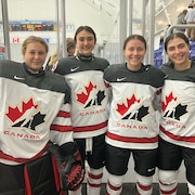 Elles posent aux abords de la patinoire dans l'uniforme de Hockey Canada.