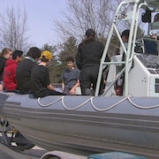 Des jeunes sont installés dans un bateau pneumatique.