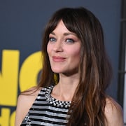 Une femme aux longs cheveux bruns sourit.