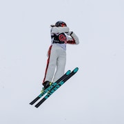 La skieuse effectue un saut dans les airs. 