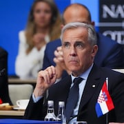 Mark Carney, l'air attentif, dans une réunion de l'OTAN.