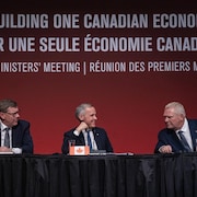M. Carney souriant entre les premiers ministres de l'Ontario, Doug Ford, et de la Saskatchewan, Scott Moe.
