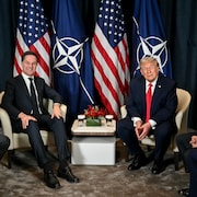 Les deux politiciens entourés de leur équipe discutent au Forum.