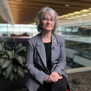 Martine Giguère assise en entrevue dans la Nouvelle Maison de Radio-Canada.
