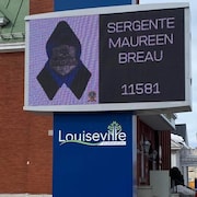 Une pancarte qui porte le nom et le matricule de Maureen Breau est apposée sur un panneau d'affichage de la ville de Louiseville.