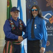 Le président de la Nation métisse de la Saskatchewan (MN-S), Glen McCallum, remet la médaille du jubilé de platine de la reine à Ernest McPherson.