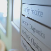 Dans une salle d'attente, différentes pratiques de médecine sont affichées au mur.