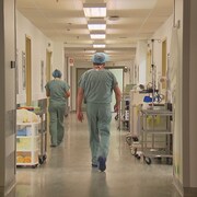 Un médecin marche dans un corridor d'hôpital