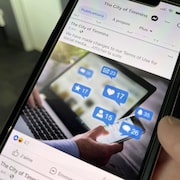 Un téléphone cellulaire avec un message Facebook sur les médias sociaux.
