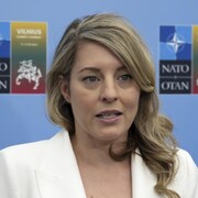 Mélanie Joly accordant une entrevue en marge d'une réunion de l'OTAN.