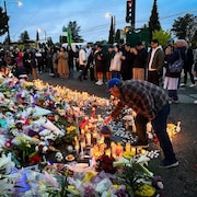 Des personnes se rassemblent devant un mémorial à Vancouver le 28 avril 2025.