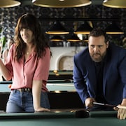 Photo d'une femme portant une chemise rose et d'un homme jouant au billard.