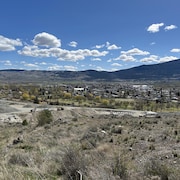 Image de Merritt prise d'une colline au nord de la ville l'où on voit le terrain de golf, la ville et les collines au fond.