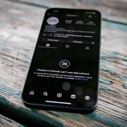 Un téléphone est sur une table en bois.
