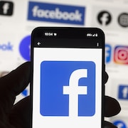 Un téléphone affiche le logo de Facebook.