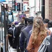 Des gens font la queue pour monter dans un autobus.