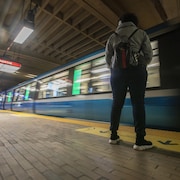 Une personne attend le métro.