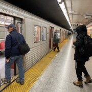 Des usagers montent à bord d'une rame de métro.
