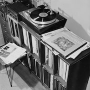 Meuble contenant des disques vinyle 33 tours et un tourne-disque.