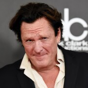 Un homme brun regarde l'objectif.