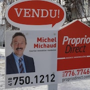 Une pancarte devant une résidence sur laquelle le nom et le portrait de Michel Michaud sont inscrits.