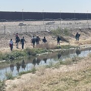 Des migrants longent le Rio Grande qui coule le long de la frontière américaine.